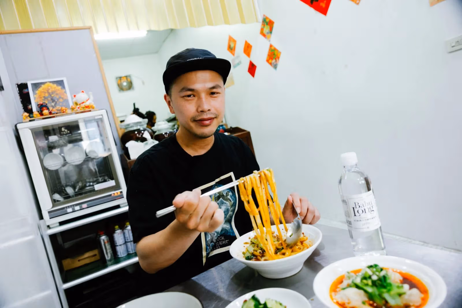 Sichuan flat noodles served alongside mineral water