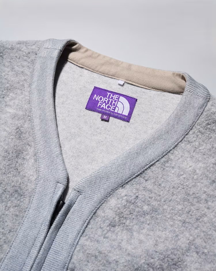 Field Jacket 목 부분 보라색 라벨과 회색 플리스 클로즈업