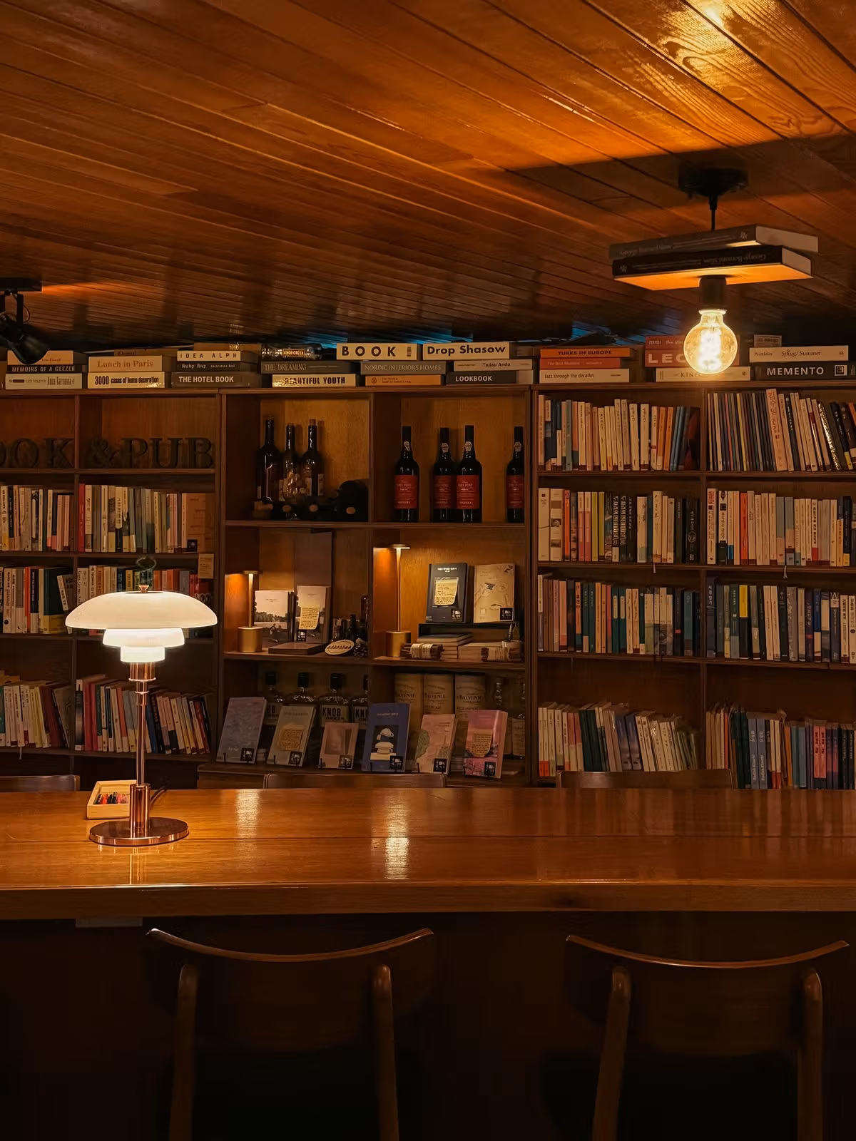 木製カウンターと棚が酒と読書を一つの机に結ぶ책, 익다。