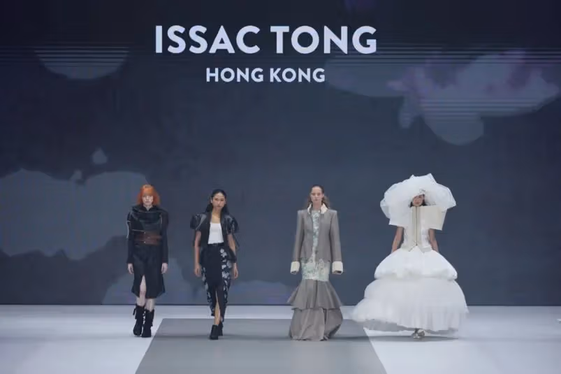นางแบบสี่คนแสดงคอลเลกชันของ Issac Tong บนเวที