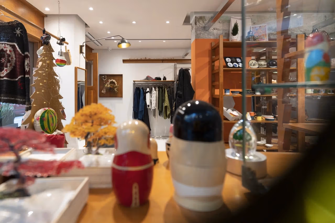 Objects on an OKURA display table with clothing behind them