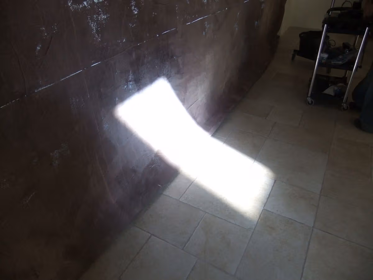 A patch of light on the interior floor brings the location’s surface texture into the image.