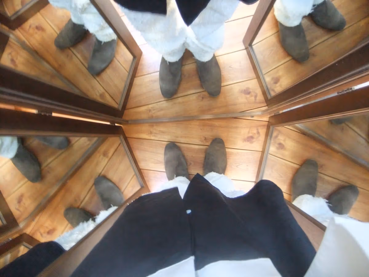 Brown suede boots photographed from above form repeated shapes in mirrors.