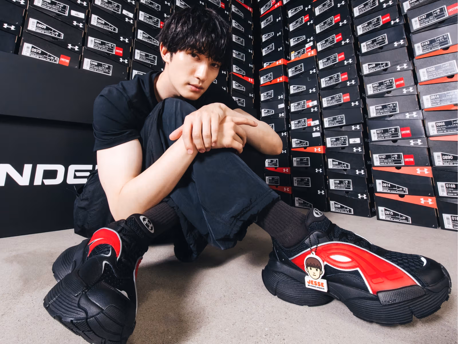 靴箱の壁の前でUA ICON 96を履くJESSE