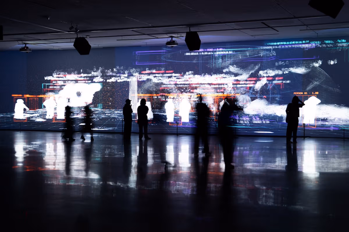 Visitors pause before a large projection.