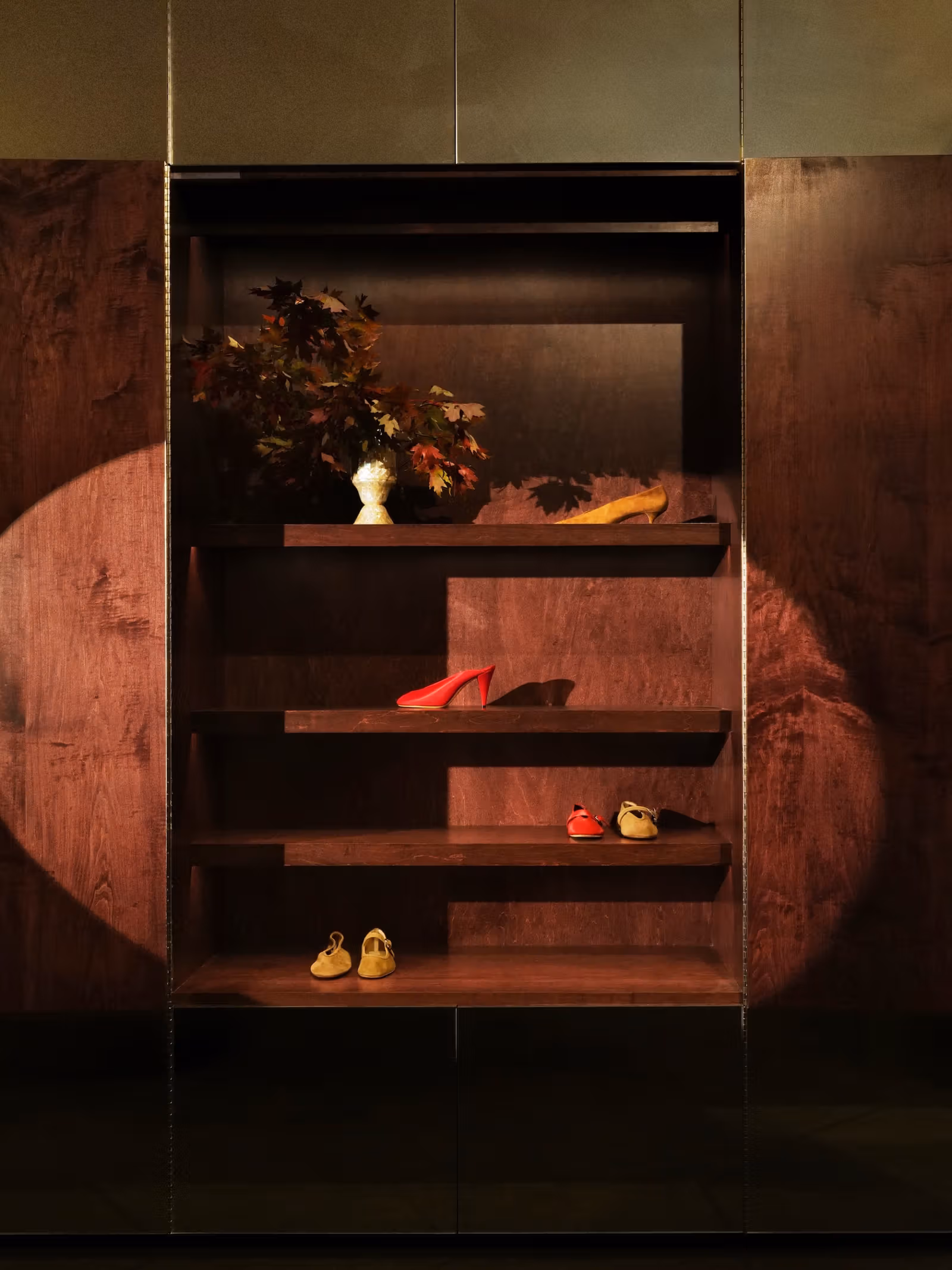 Shoes and objects displayed in Le Monde Béryl wood cabinets
