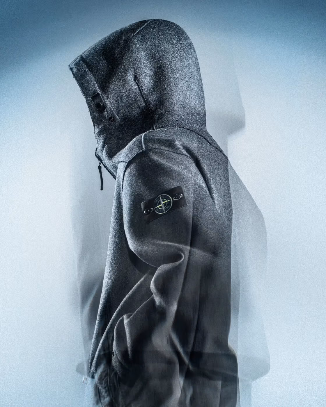 The side silhouette of a hooded jacket and its sleeve badge.