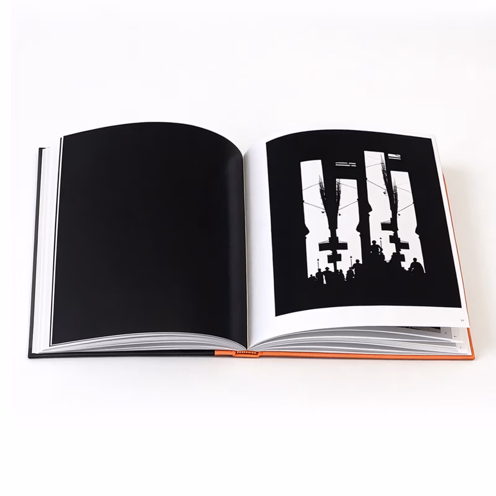 An open photobook with architectural openings and human silhouettes on the right-hand page