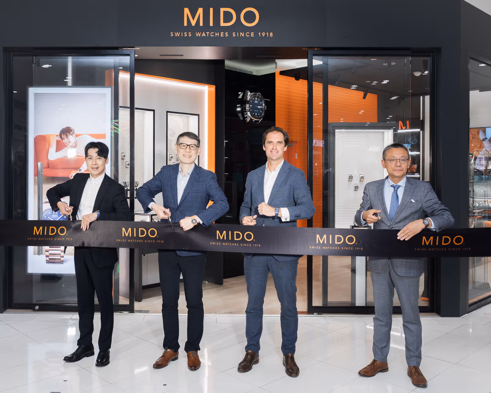 开幕剪彩合照，背景可见MIDO旗舰店入口及展示区。