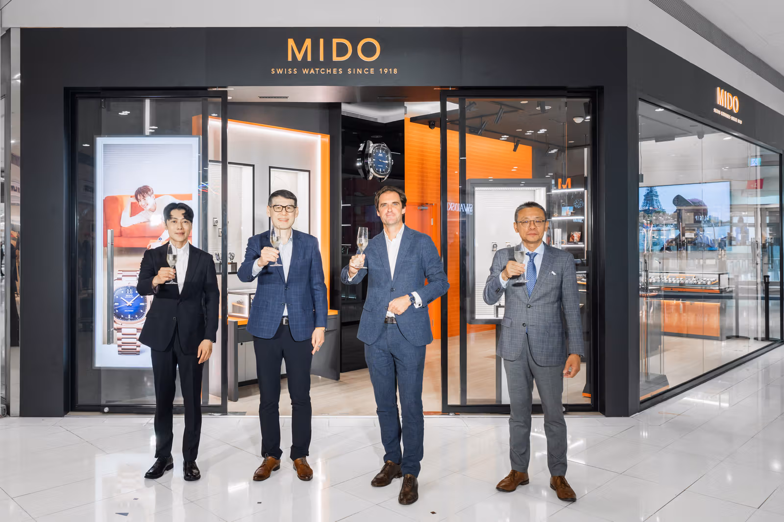 开幕活动合照呈现店面两侧的玻璃展示立面。