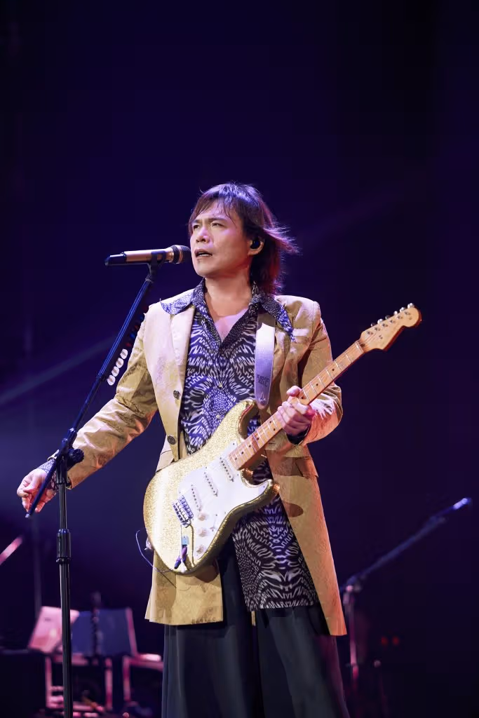 ภาพประชาสัมพันธ์อู่ไป๋ถือกีตาร์บนเวทีการแสดง