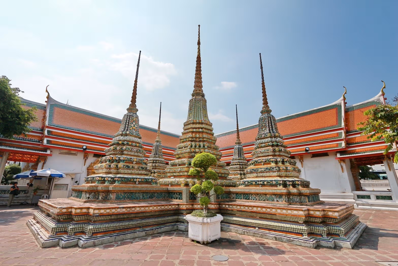 Colourfully decorated stupas and orange-and-green roofs in Wat Pho’s courtyard, not a 2026 installation view