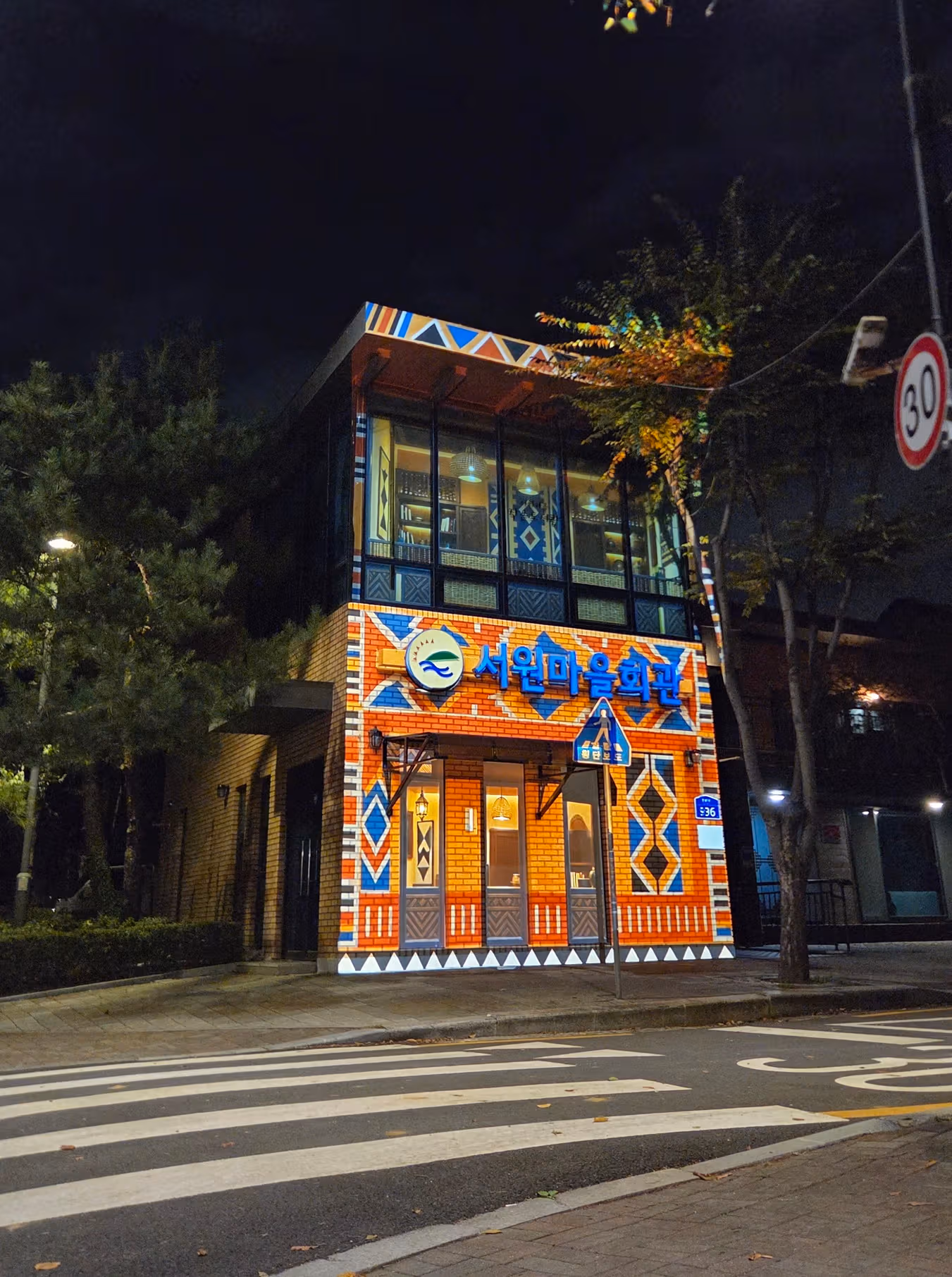 Seowon Village Hallの既存の窓枠、煉瓦、看板を取り込む多色の投影。