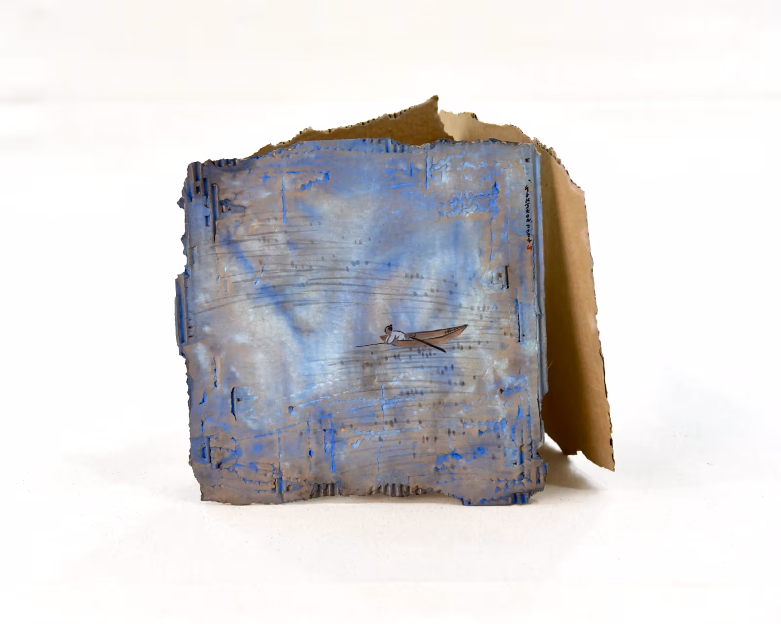 A small boat on blue-painted cardboard, with folded side panels showing depth and support