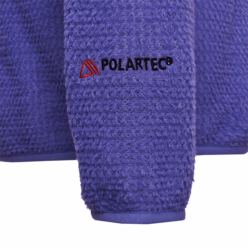소매 끝 마감과 Polartec 자수 디테일. 로고는 의류 본체에 있다.