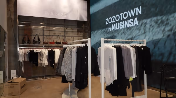 Clothing rails, bags and wall branding organize different products within the pop-up.