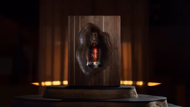Curving layers on a dark wooden side surround the 88-year-old bottle