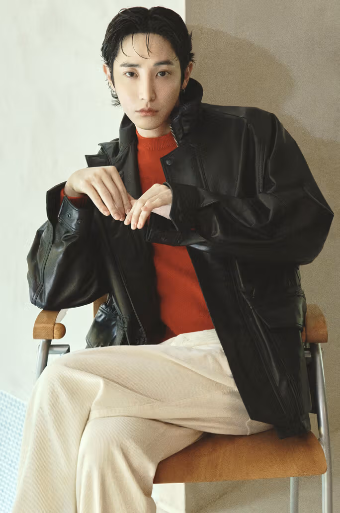 黒いレザージャケットに赤いクルーネックニットとクリーム色パンツを合わせ、前立てとポケットの線を簡潔に見せる。