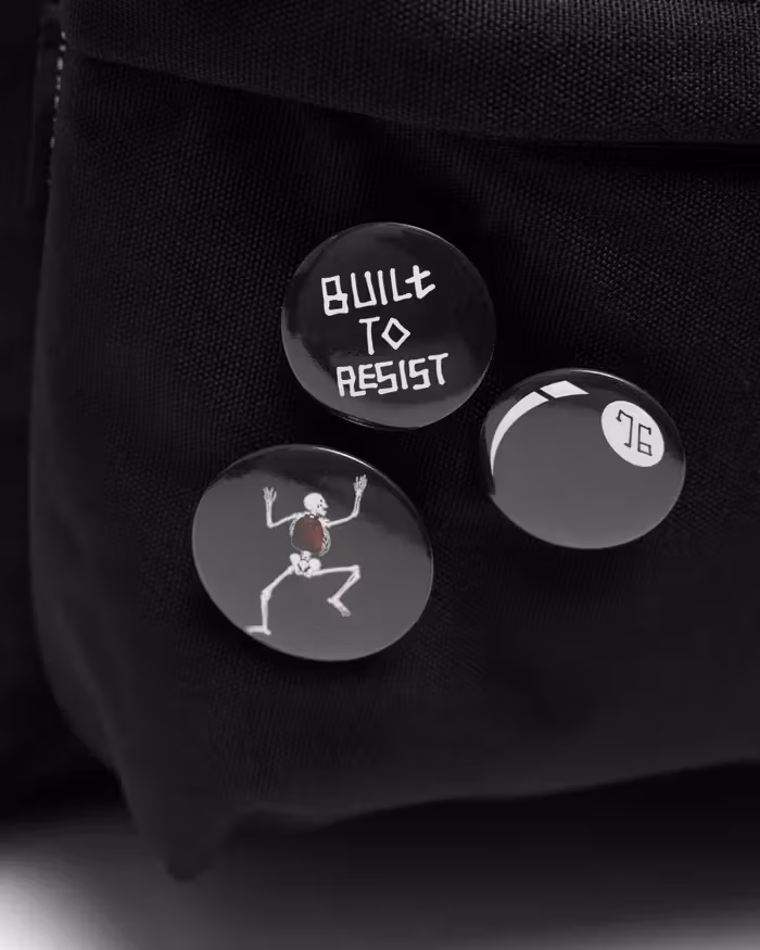 Close-up of three badge designs, including one reading Built To Resist.