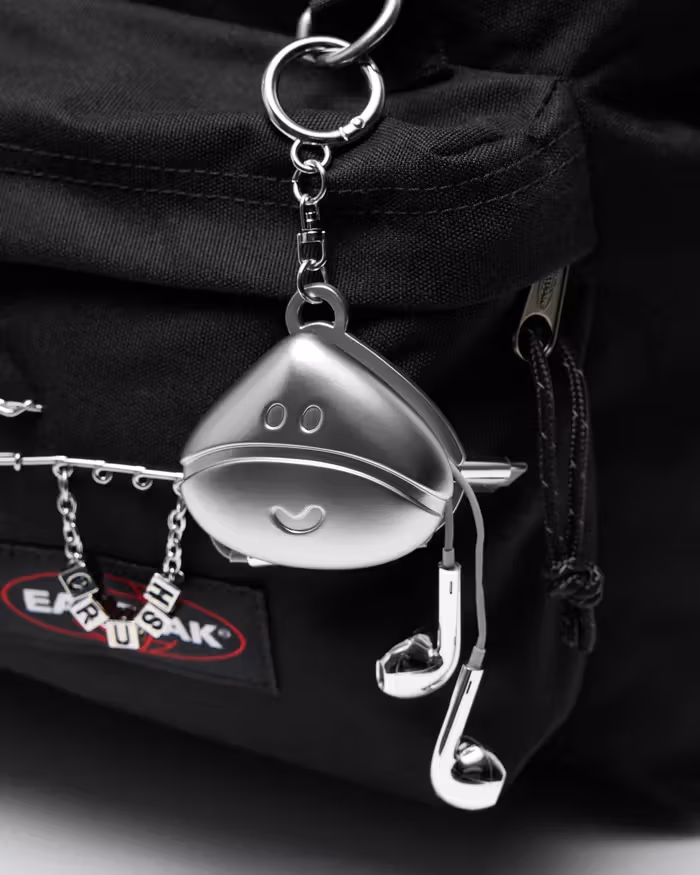 Close-up of the silver-colored character charm and chain, with earphone-related objects also pictured; gift conditions require separate checking.