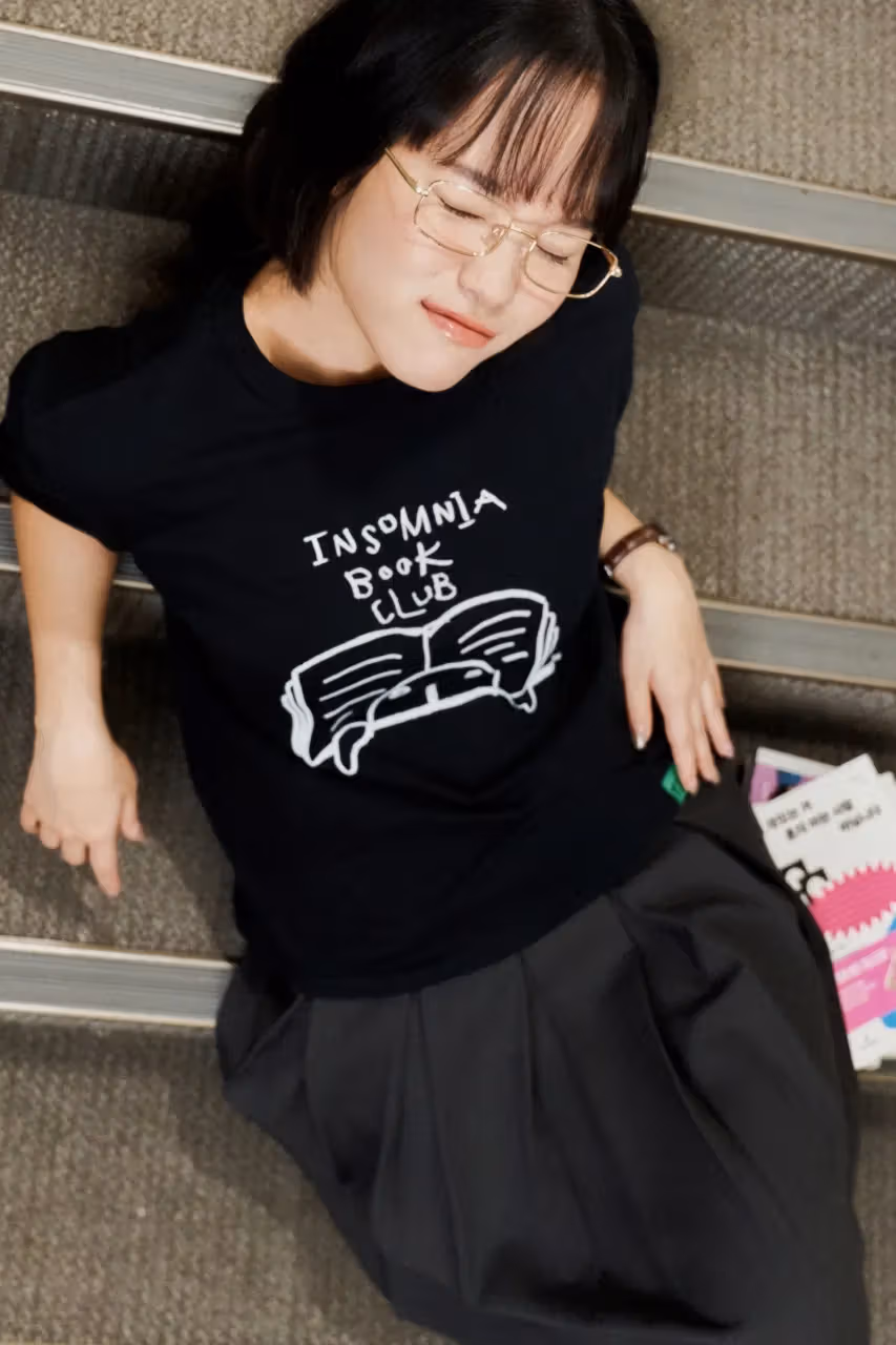 펼친 책 그림과 Insomnia Book Club 문구가 있는 검정 티셔츠