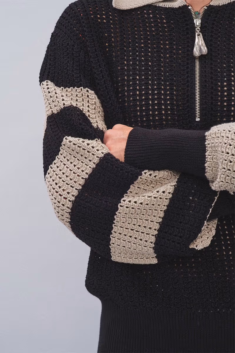 Black-and-ecru striped knit open-stitch detail