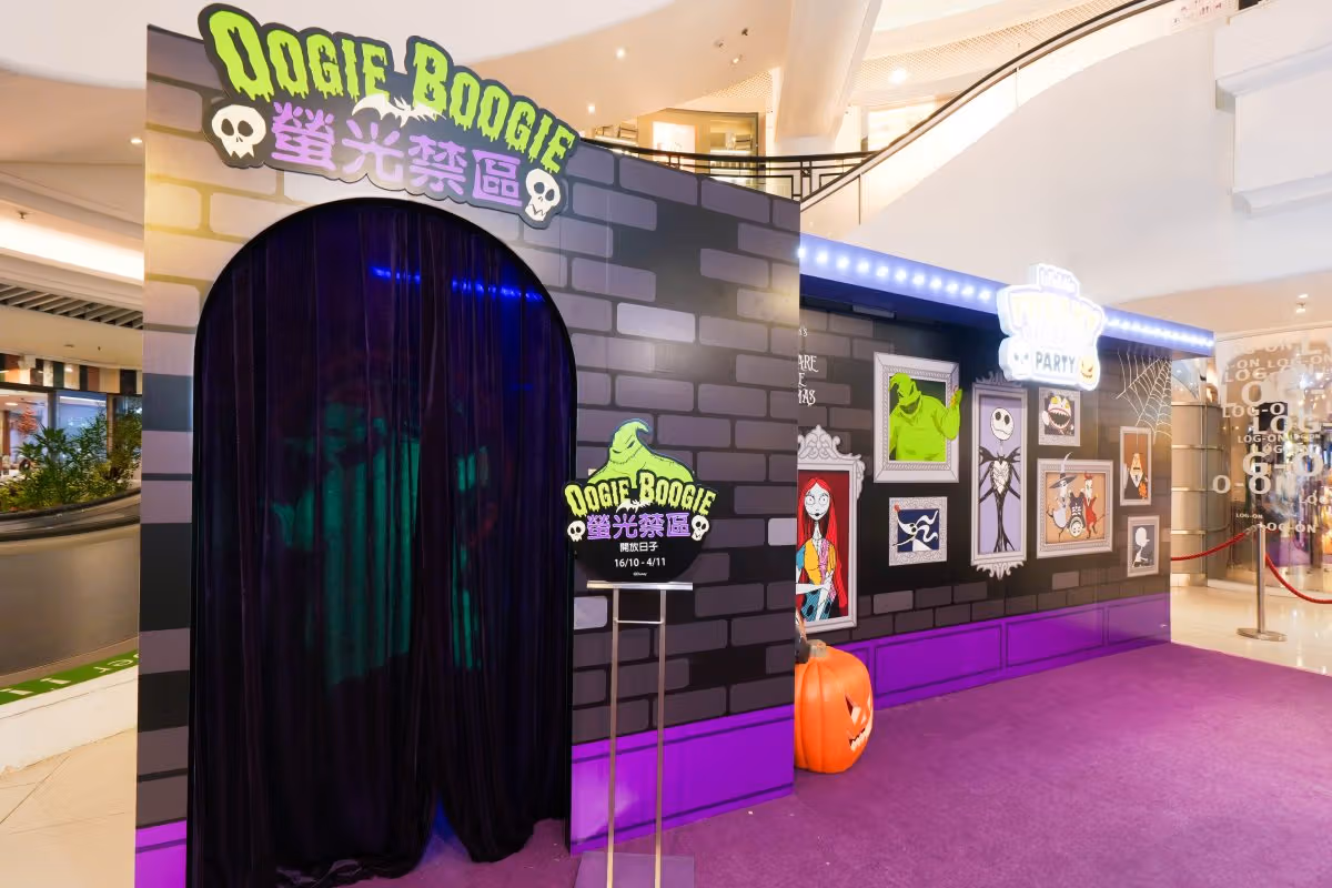 ม่านประตูดำใต้ป้าย Oogie Boogie สีเขียวสะท้อนแสง ข้างผนังภาพตัวละคร