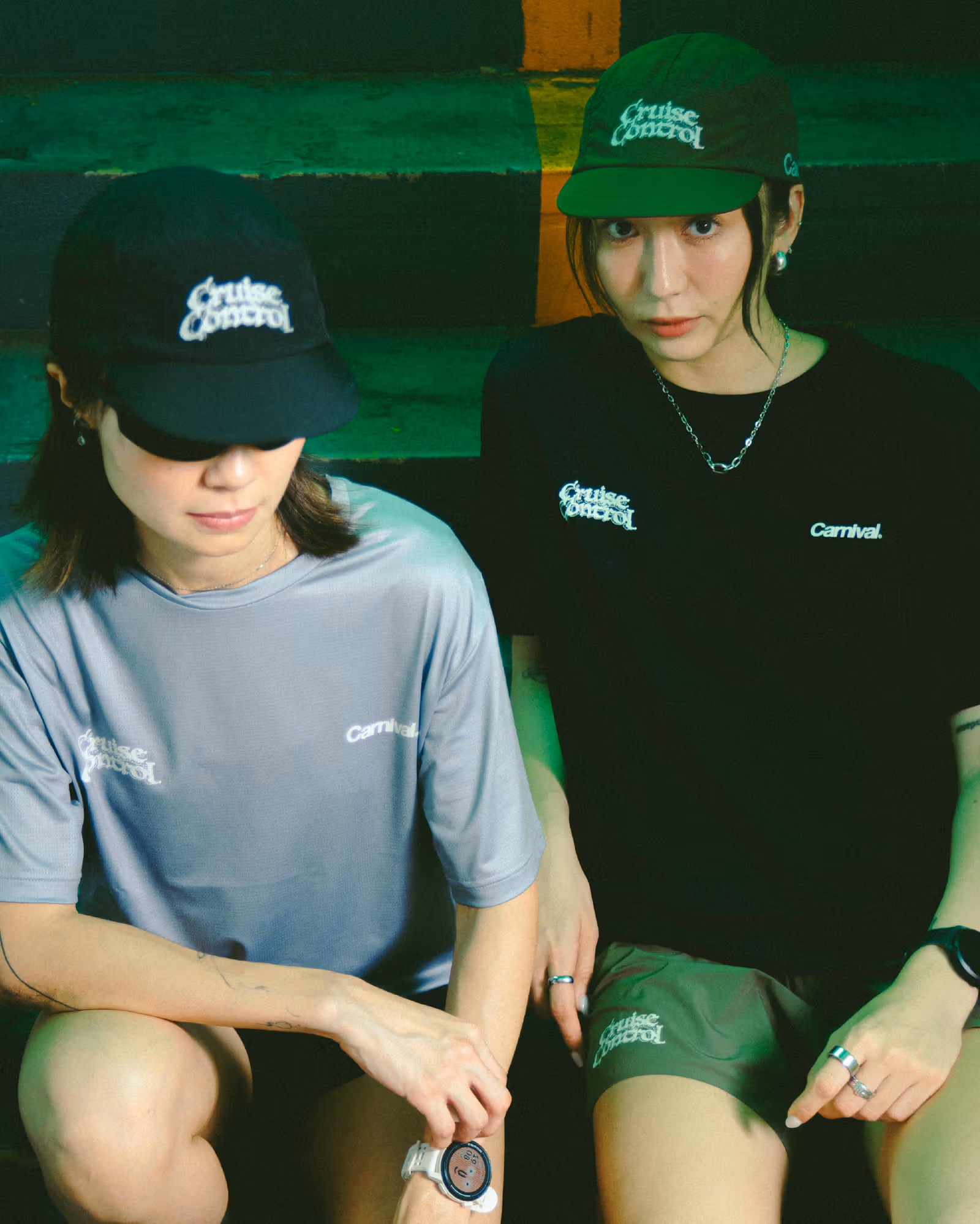 Cruise Controlの帽子をかぶった2人が座る。一人はグレーブルー、もう一人は黒のTシャツ