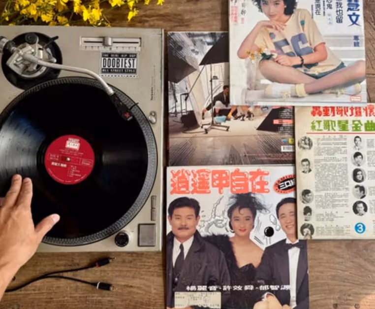 Side-by-side images of a black record player and Taiwanese song record sleeves