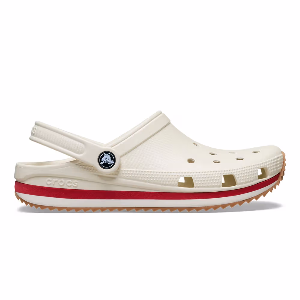 흰 배경의 베이지 Crocband Runner 옆면에 빨간 중창 띠, 통기 구멍, 톱니형 생고무색 밑창이 보인다.