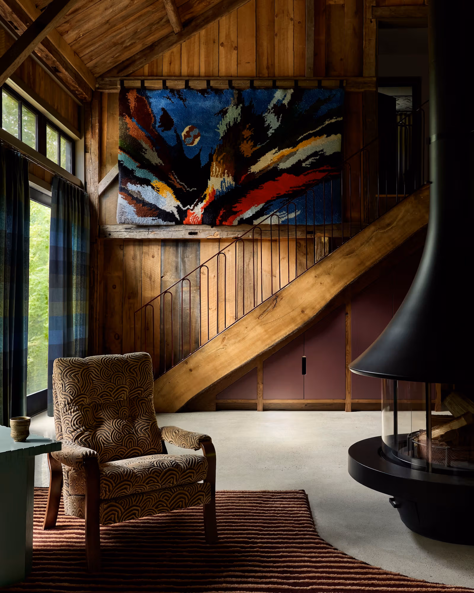 Large colourful heirloom textile above a wooden staircase