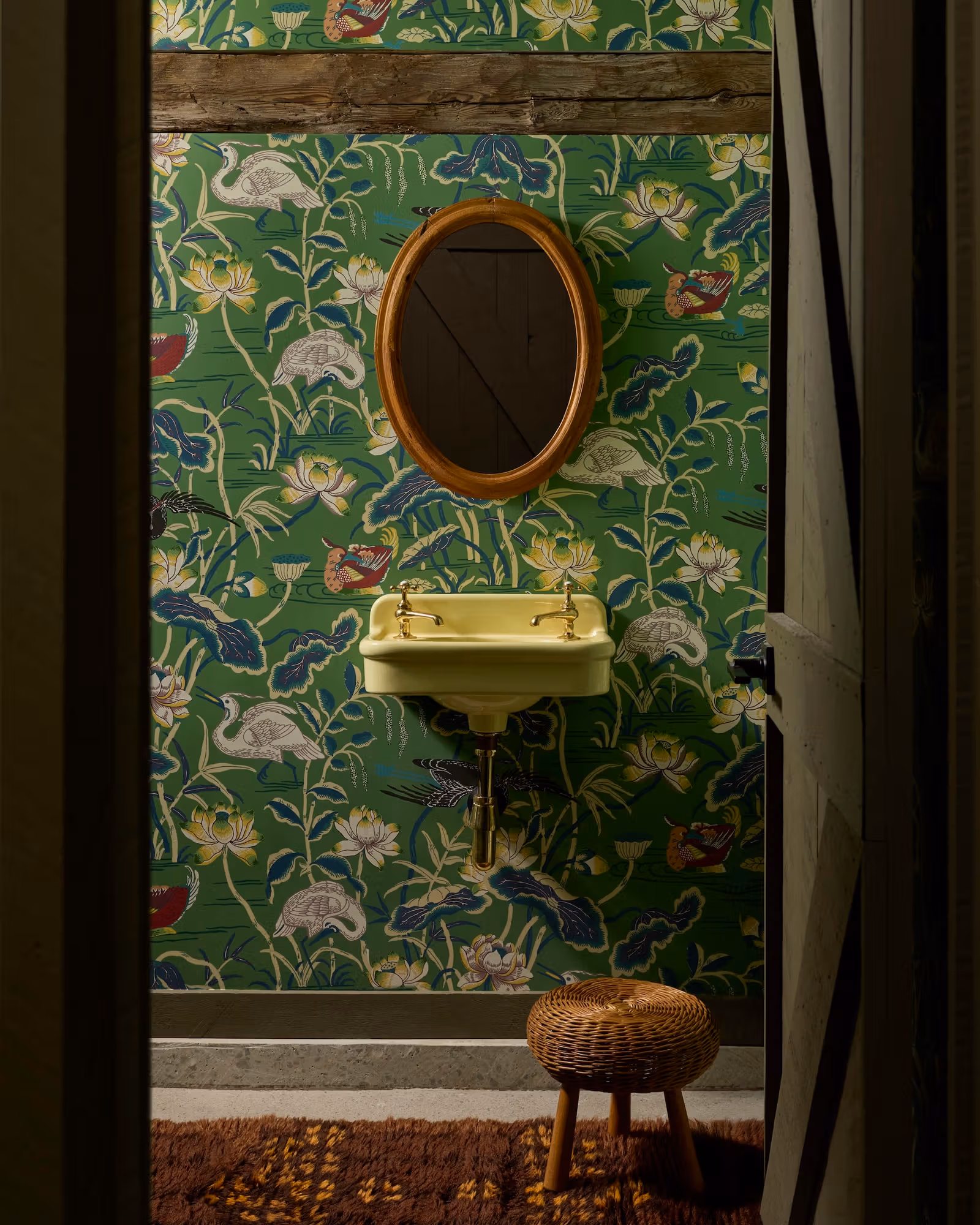 Botanical and bird wallpaper with a light-green powder-room basin