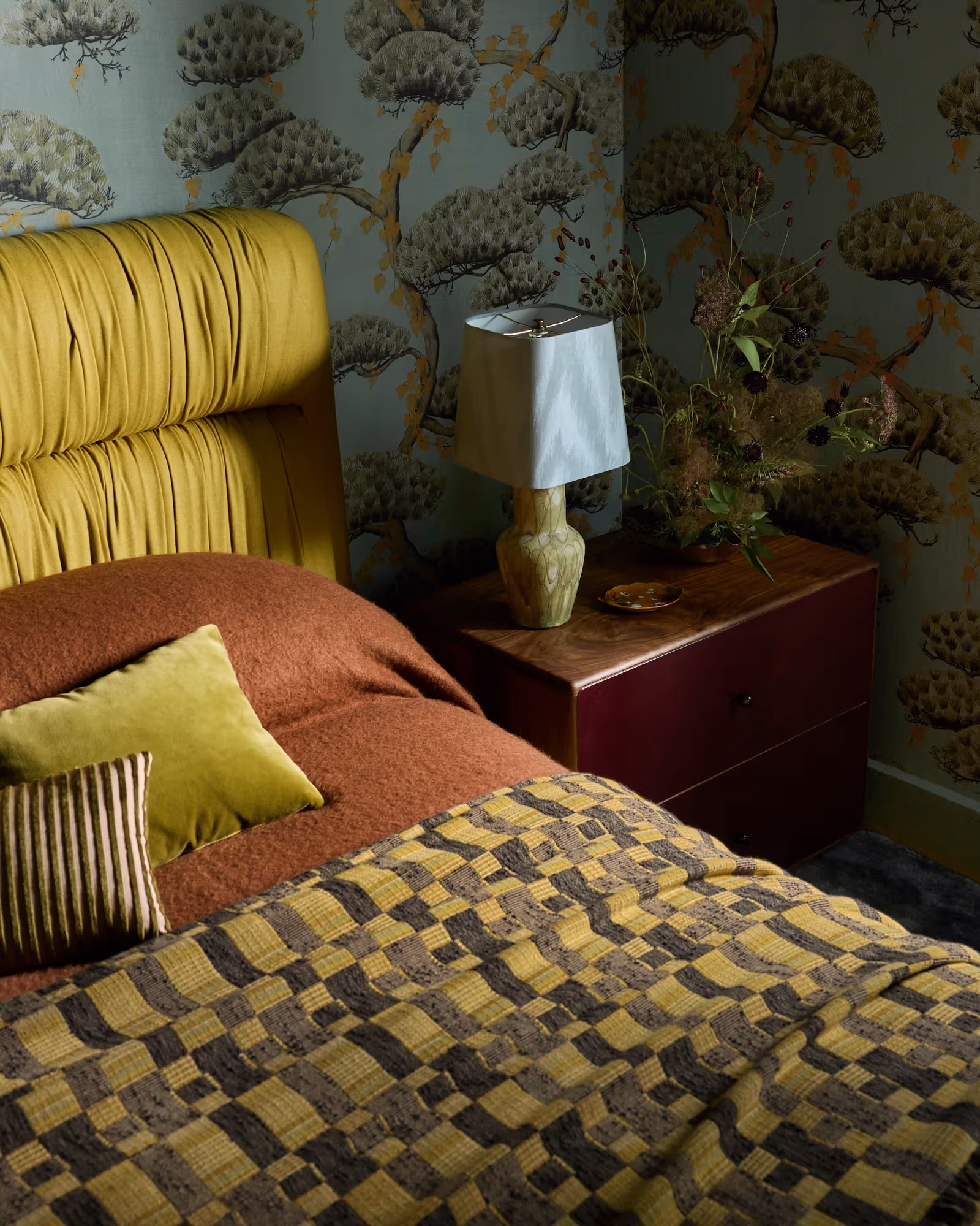 Yellow headboard, botanical wallpaper and bedside lamp in the main bedroom