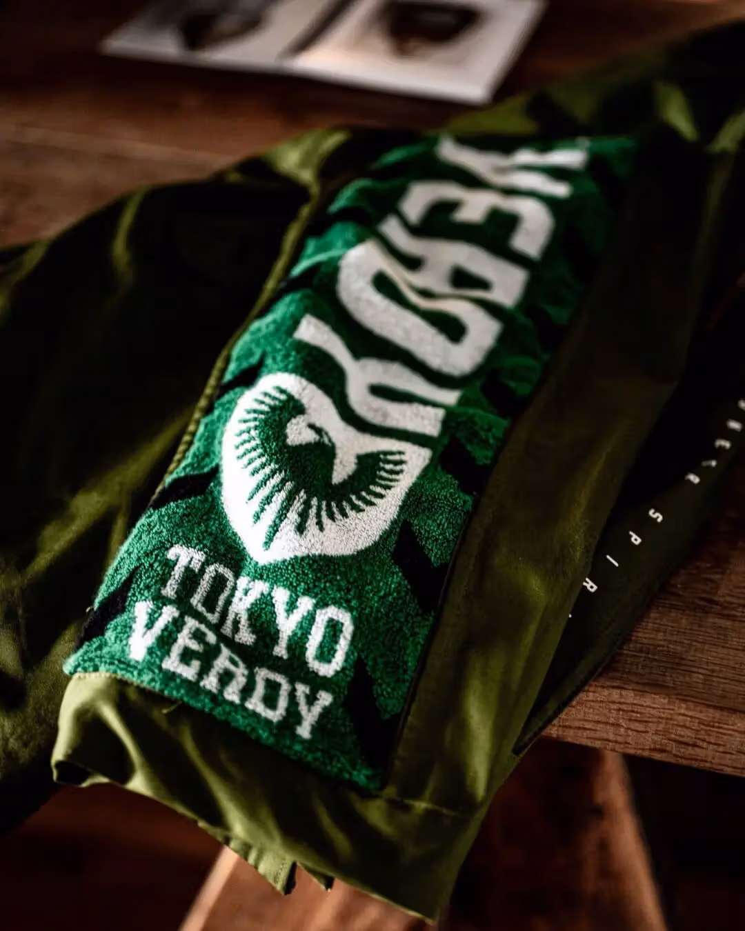 รายละเอียดผ้าเชียร์ Tokyo Verdy ที่ตัดต่อบนแขนโค้ตสีเขียว
