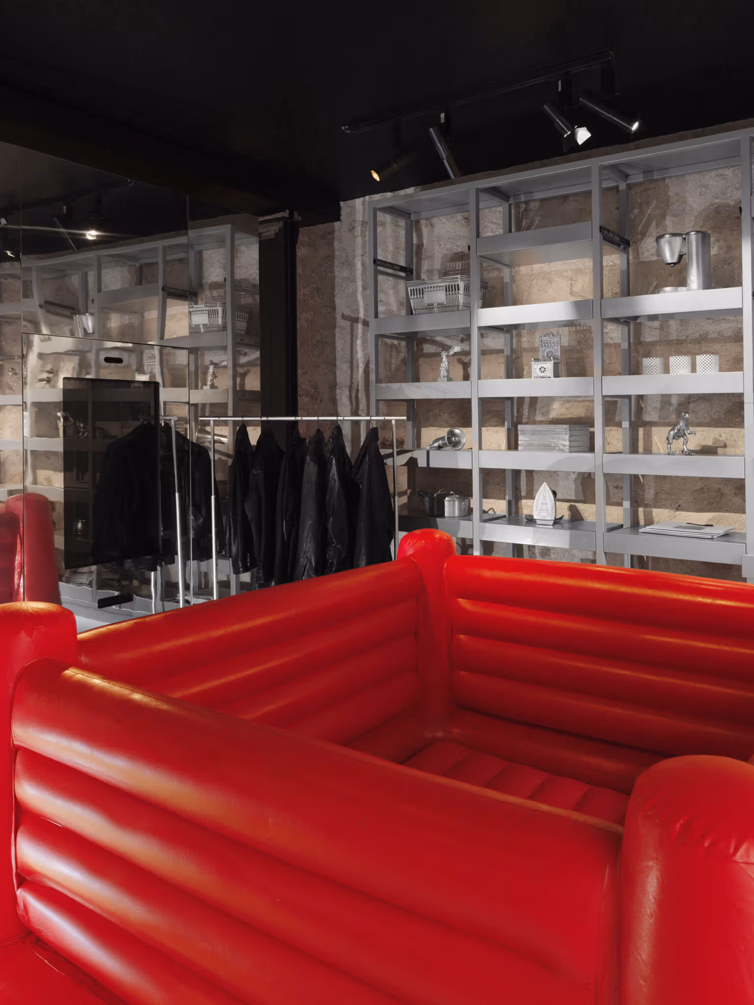 A red padded boxing-ring-like structure in front of dark leather jackets