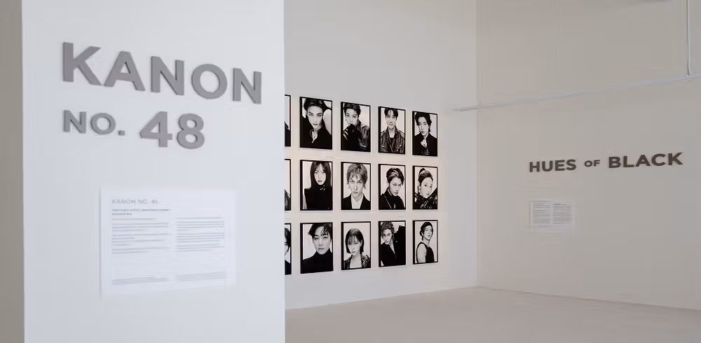 흰 벽의 KANON NO.48 글자와 흑백 인물 사진