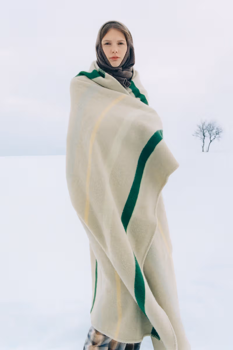 模特儿在雪地裹奶油色绿条纹毛毯