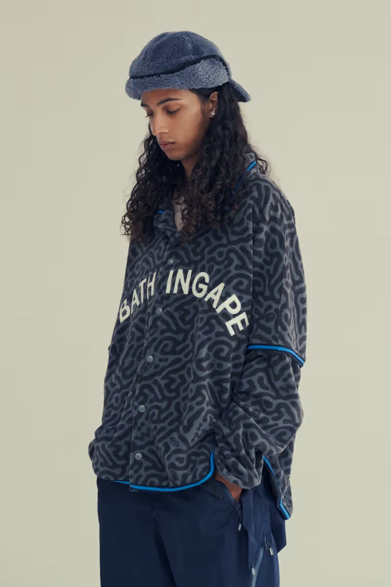 A model in a dark-gray maze-pattern top and gray furry hat