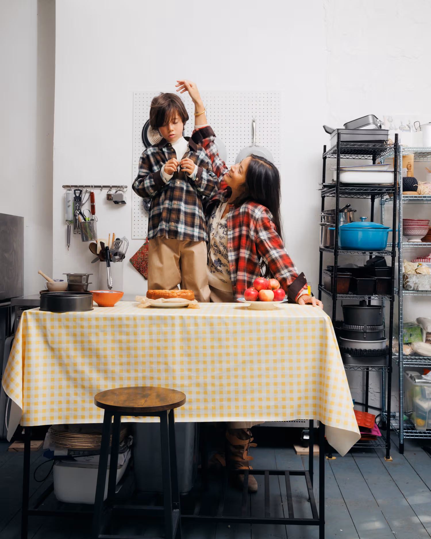 Kim’s Paris family interacting beside a kitchen table in checked clothing