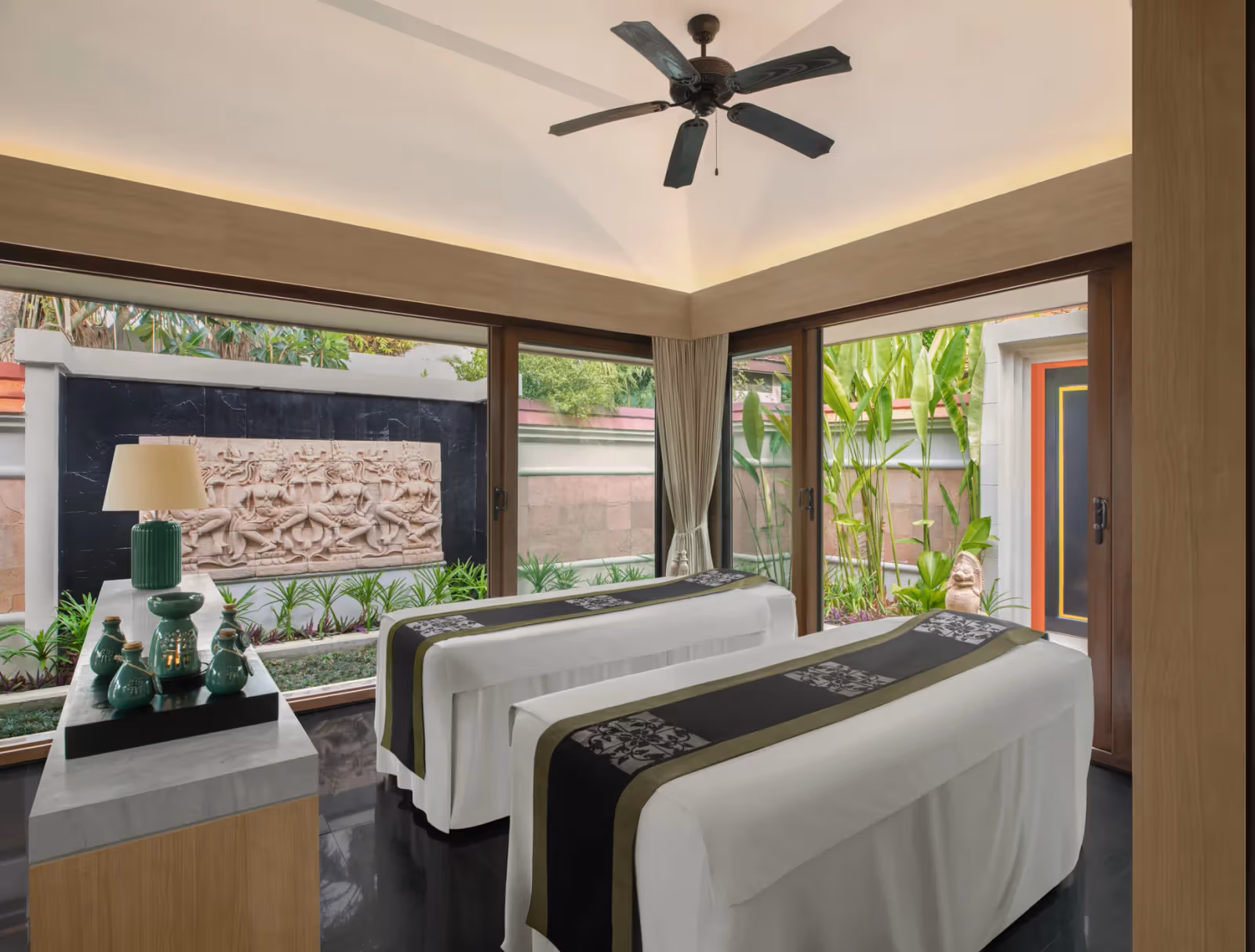 Banyan Tree Phuket 水療空間內有兩張療程床、大片玻璃與窗外植栽。