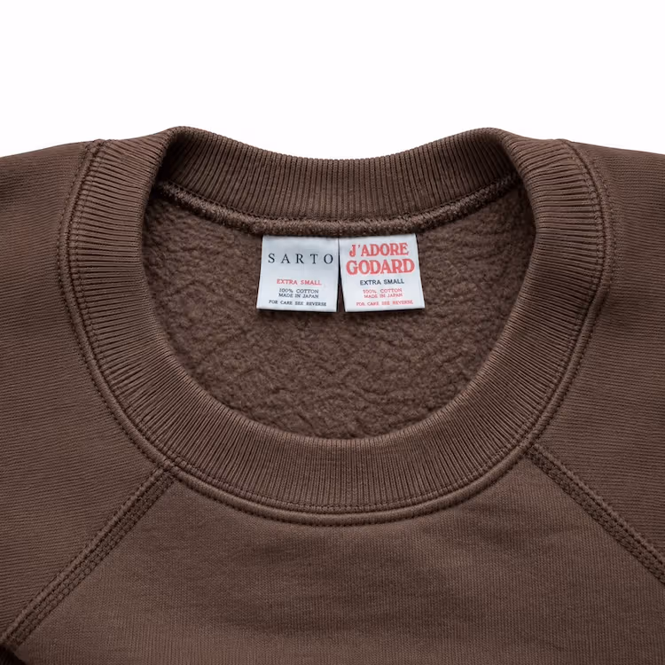 Dark brown sweatshirt neckline with SARTO and JʼADORE GODARD labels