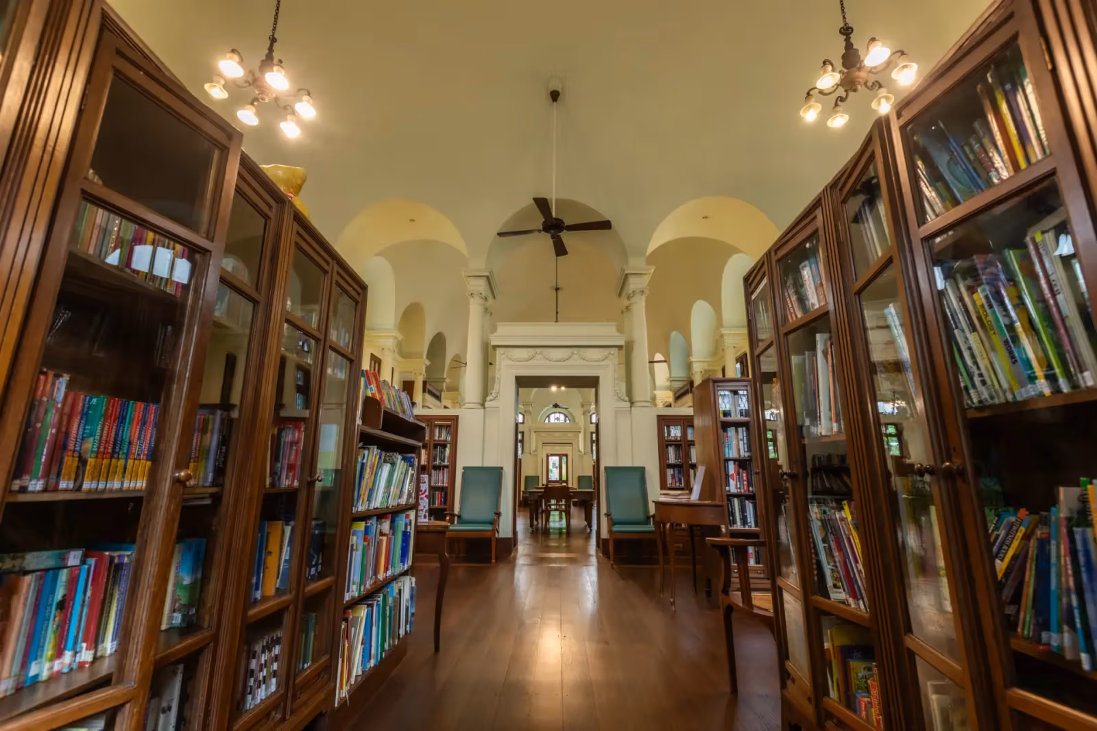 Neilson Hays Library 室內，兩側為木製書櫃，中央可見拱形門洞與吊扇。