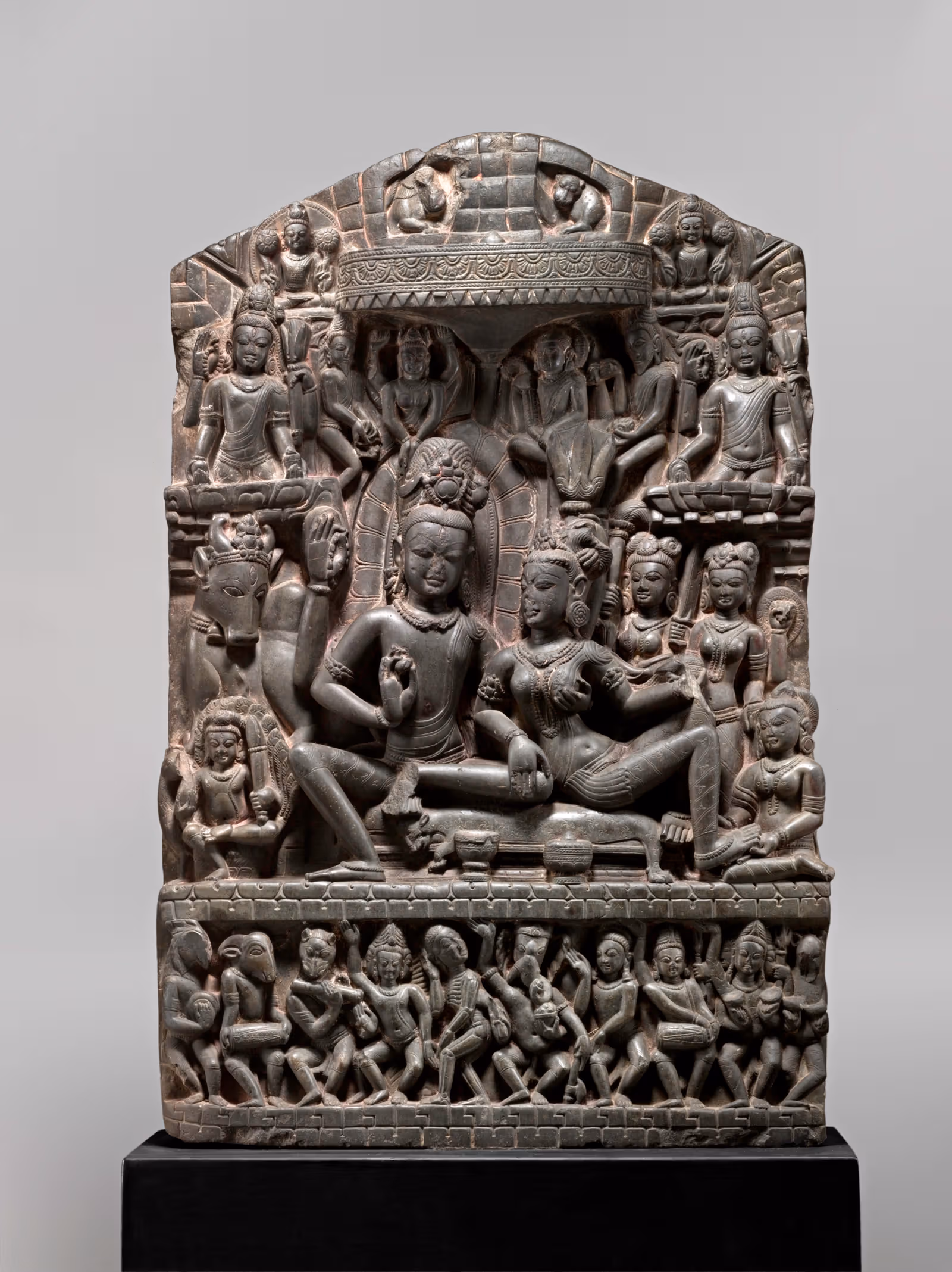 หินแกะ Umamaheshvara มีบุคคลกลาง รูปรอบข้าง และรูปเล็กแนวนอนด้านล่าง
