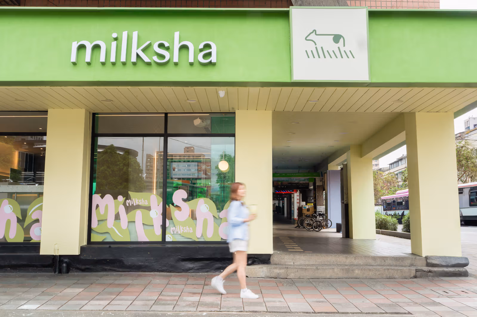 The new cow symbol and milksha lettering, with pink-and-green window graphics below.