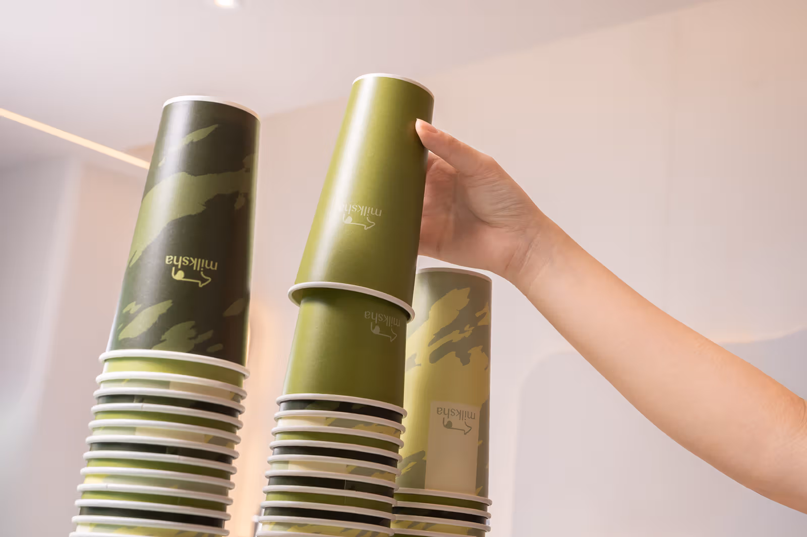 New paper cups in varied greens and natural light-and-shadow patterns.