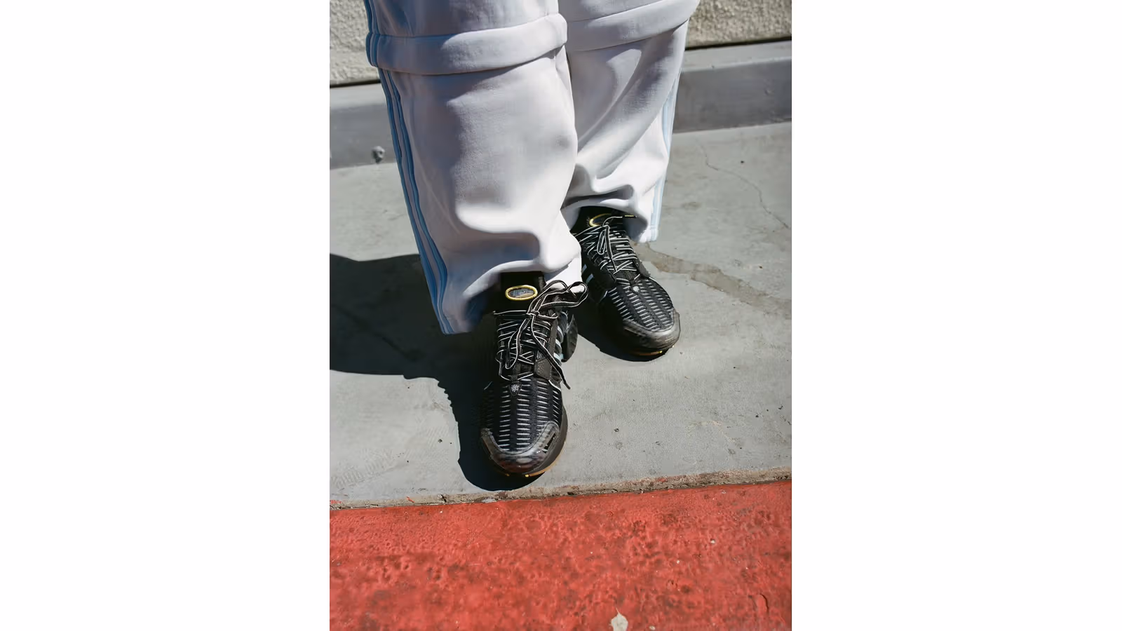 Official styling detail showing trouser-leg joins and black sneakers.