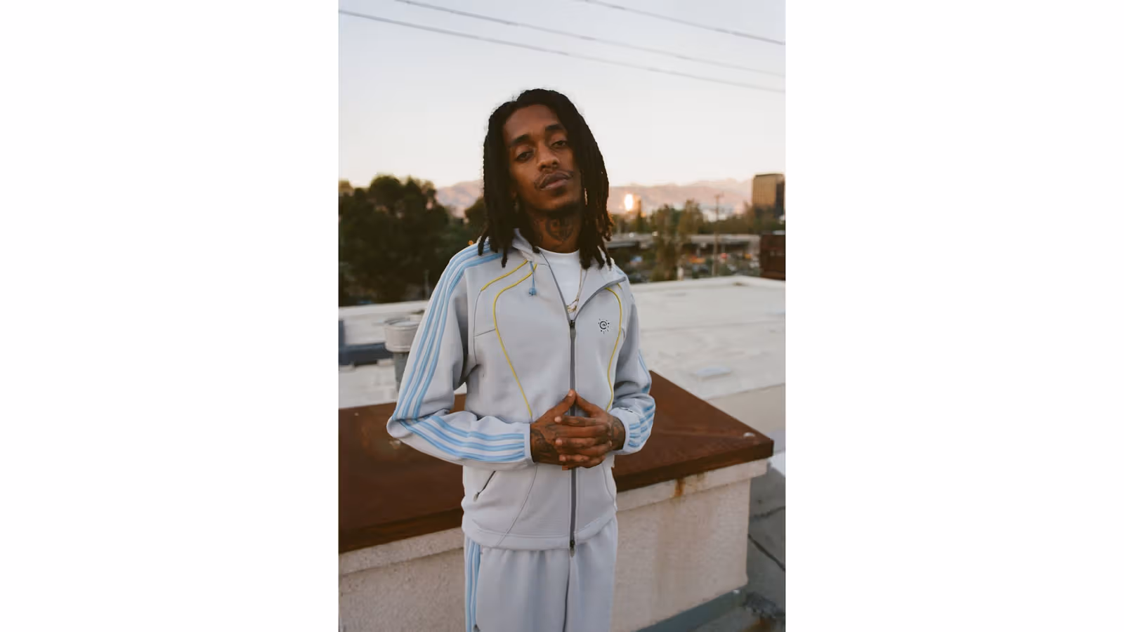 Brand image of the grey tracksuit with light-blue stripes and yellow piping.