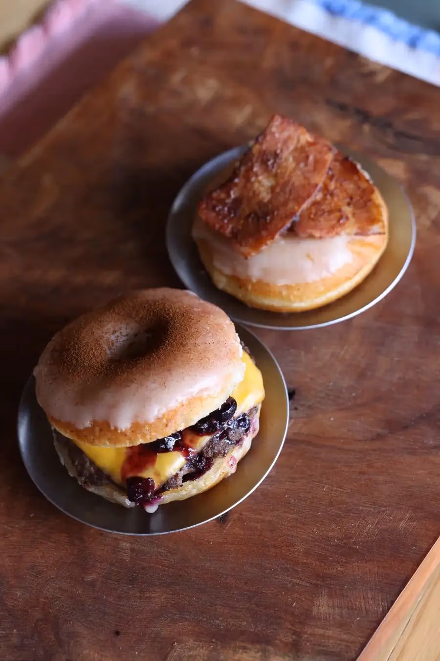 food & donut Nejiとの公式フード写真。奥はベーコンドーナツ、手前はドーナツバーガー。