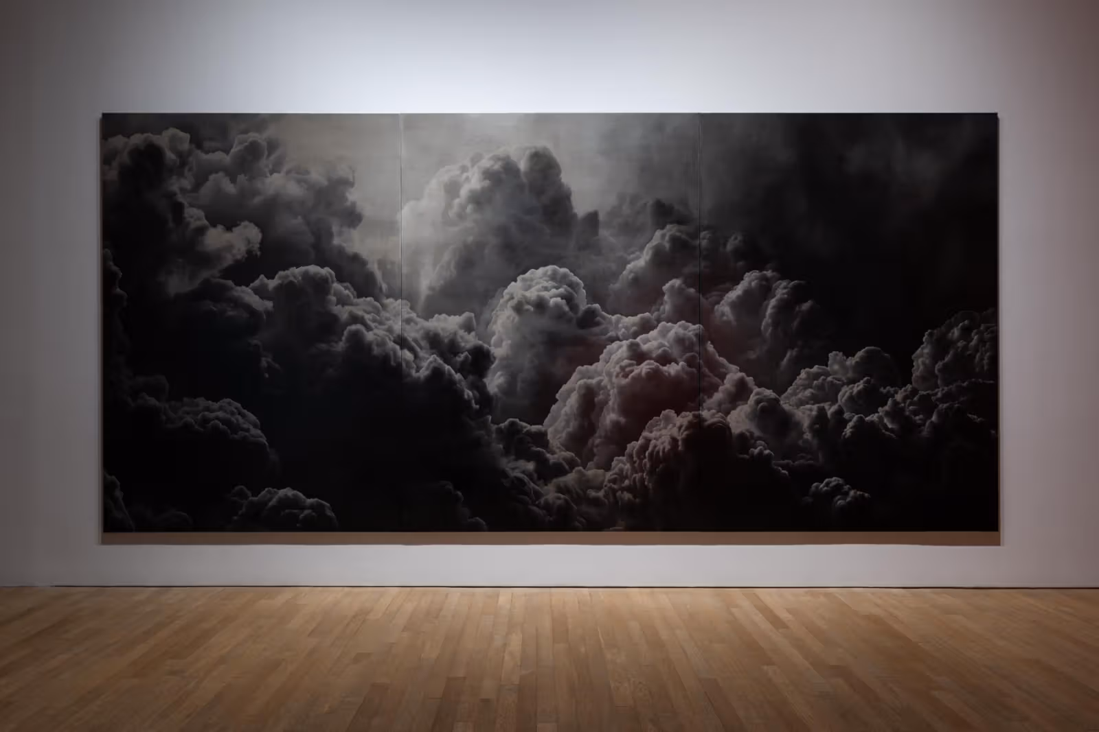 Installation view of Anne Imhof's Untitled (2026), a three-panel oil painting with dark grey clouds.