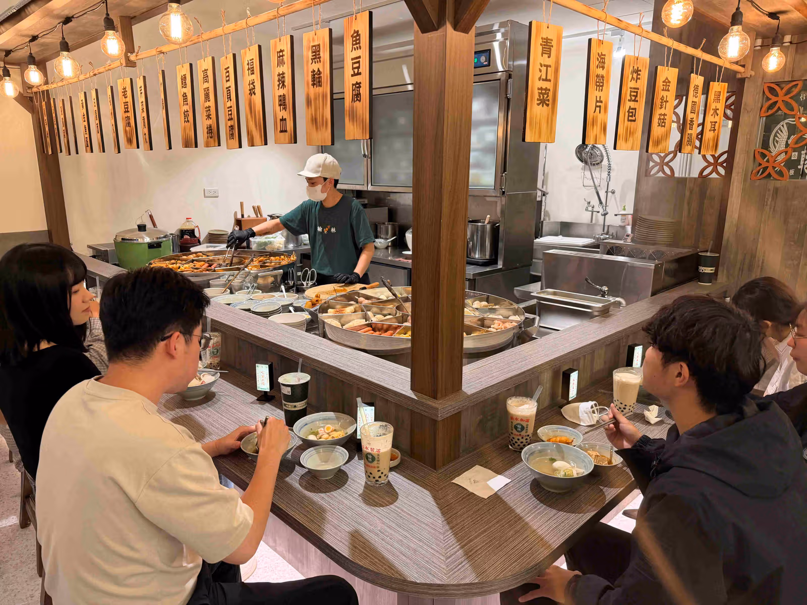 조리대를 둘러싼 좌석이 있는 타이베이 Qsquare 한린차잔 카운터형 매장.